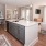 well lit kitchen with island sink, wooden floors and stainless steel appliances